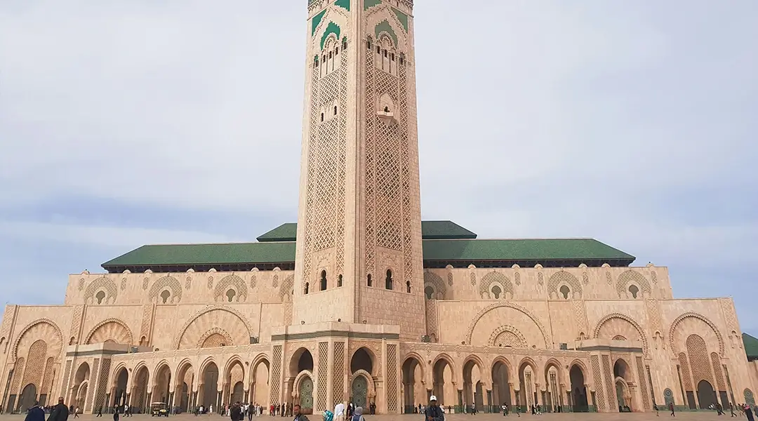a large building with a tall tower with Hassan II Mosque in the background
